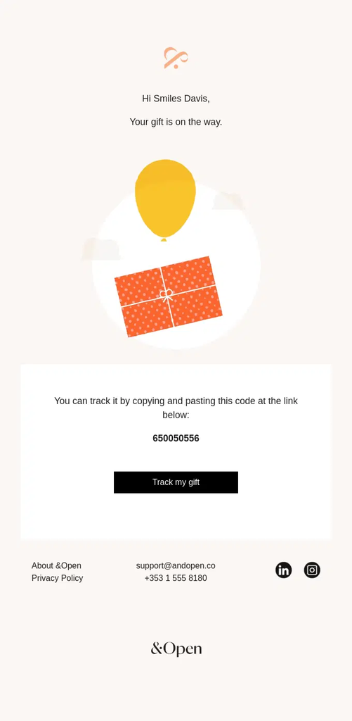 &Open minimalist shipping confirmation email letting the customer know that their gift is on the way, with a tracking code, Track My Gift button, simple gift illustration, and customer support details.
